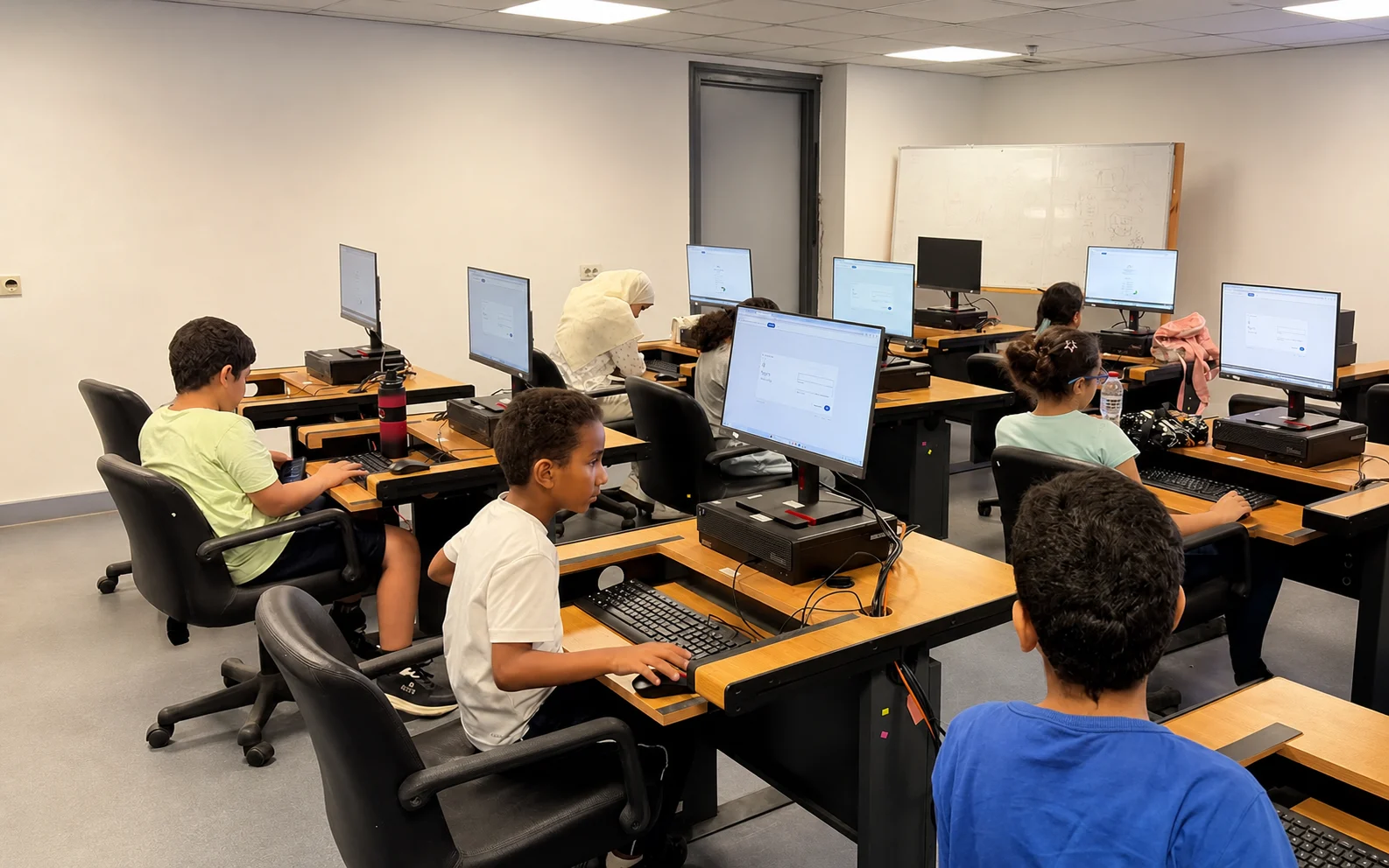 Students working independently at academy computer stations