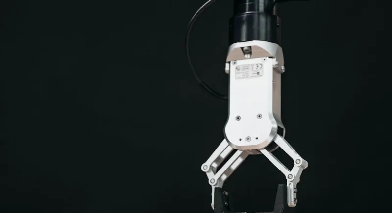 Servo-driven robotic arm closing its gripper on an object